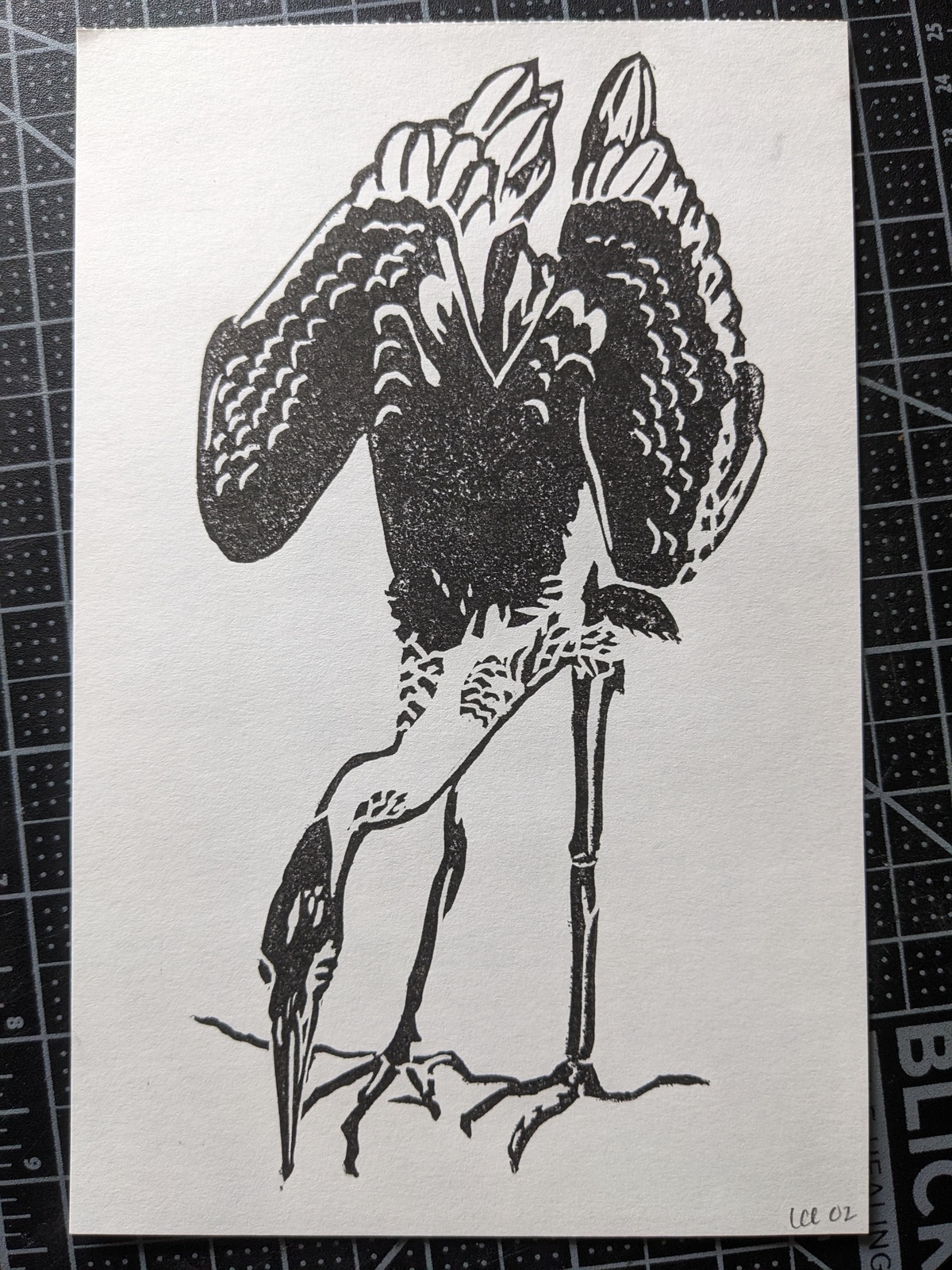 A print in black ink of a great blue heron, leaning downwards so that eir beak is level with eir feet.