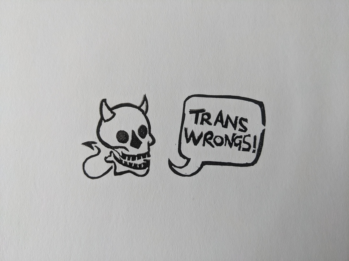 A smiling skull with devil horns and a little spiked tail, and a speech bubble reading 'trans wrongs!'
