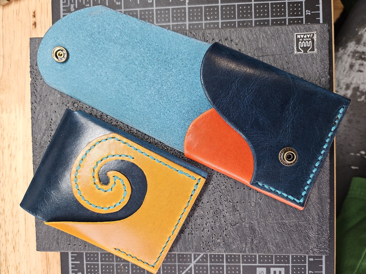 A collage showing 3 pictures of a red and brown leather card wallet. The red pocket separator folds around to the back to become a fetching curlicue.