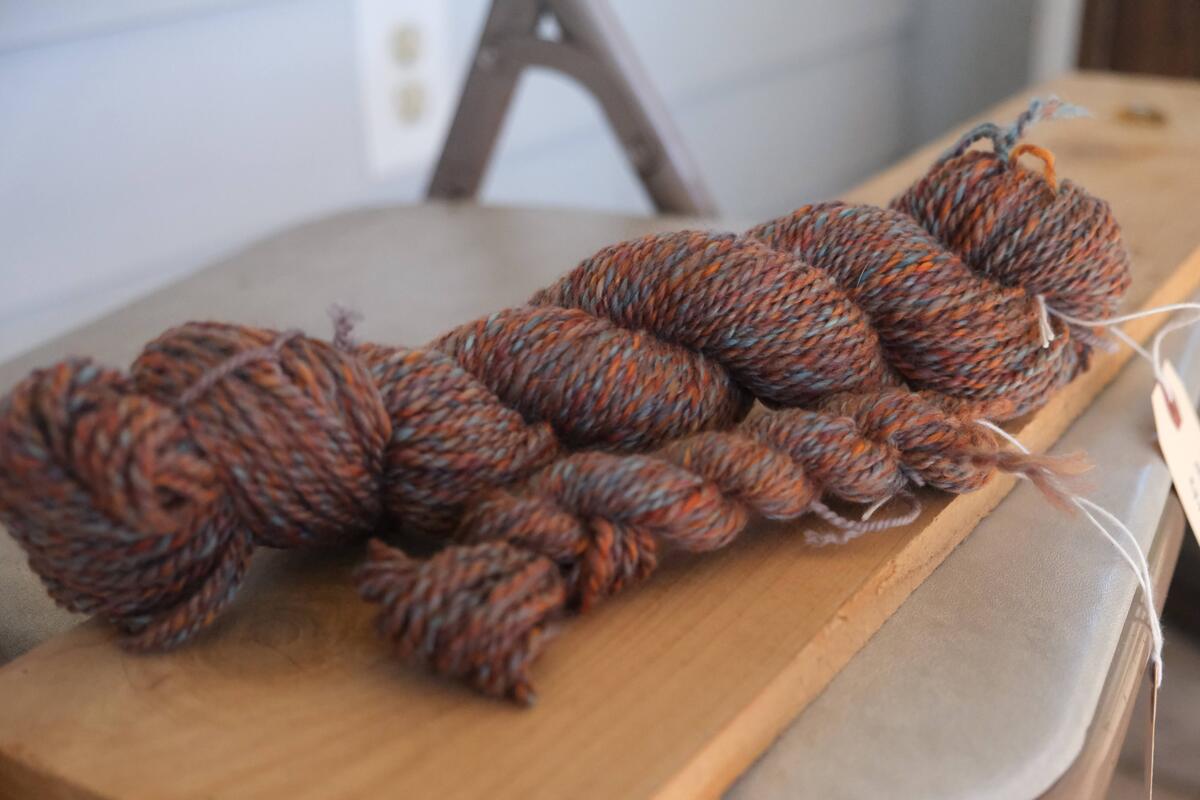2 skeins, one large and one small, of a heathered orange yarn with hints of blue in about a DK or worsted weight.
