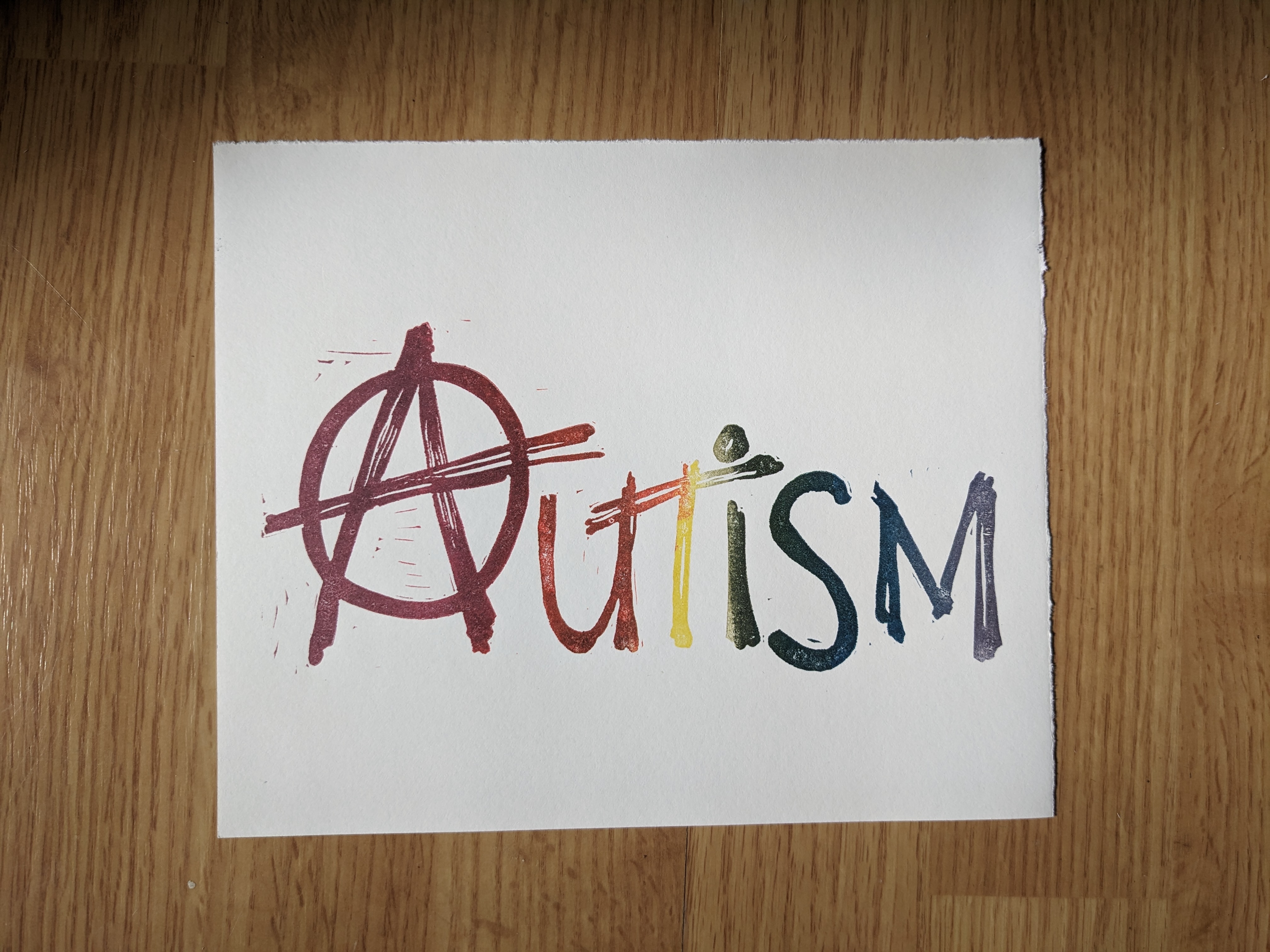 A print in rainbow ink that says autism with the anarchy A.