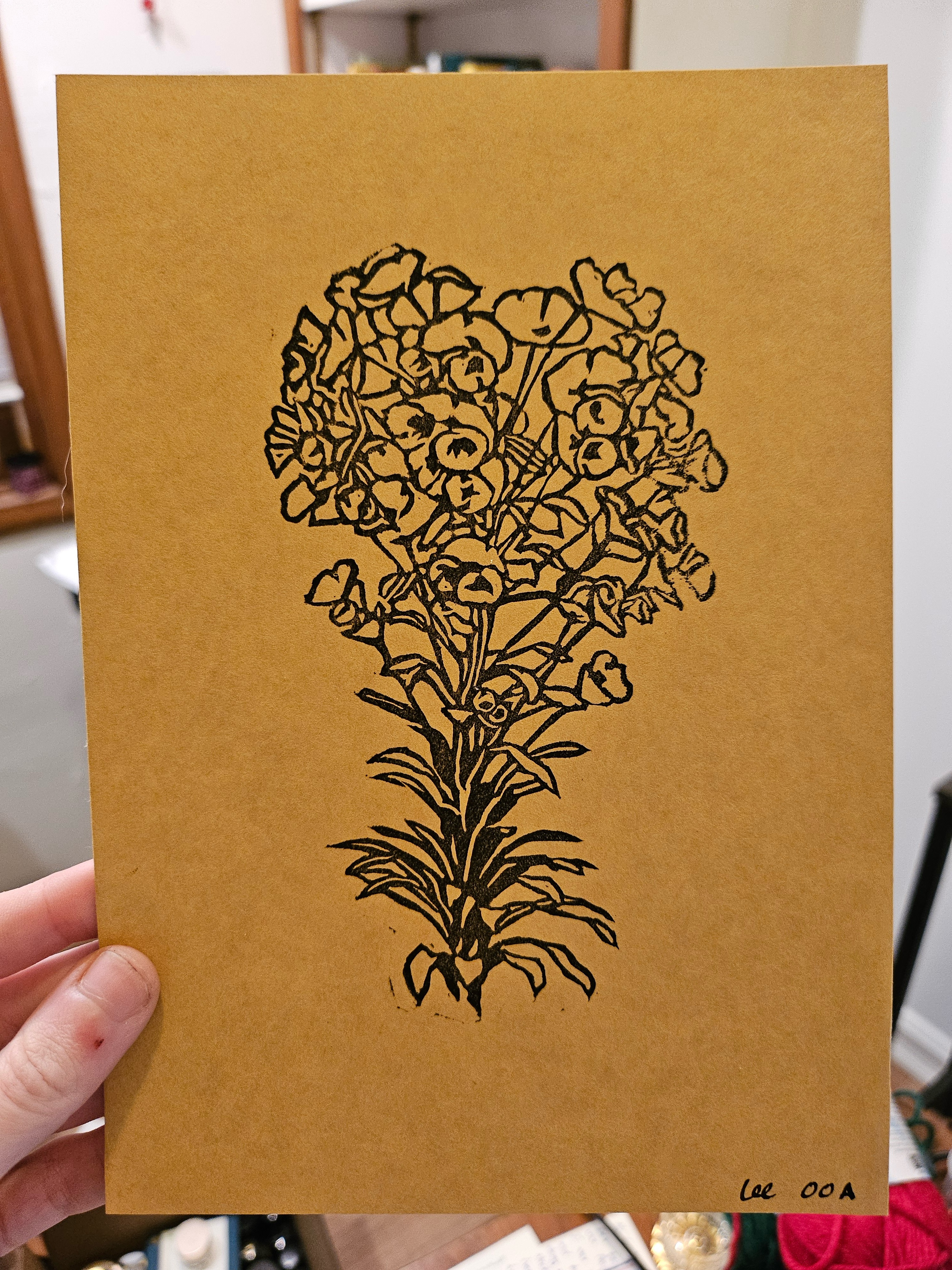 A print in black ink on brown paper. It depicts a stem of euphorbia, a plant with long, thin leaves and many clustered flowers.