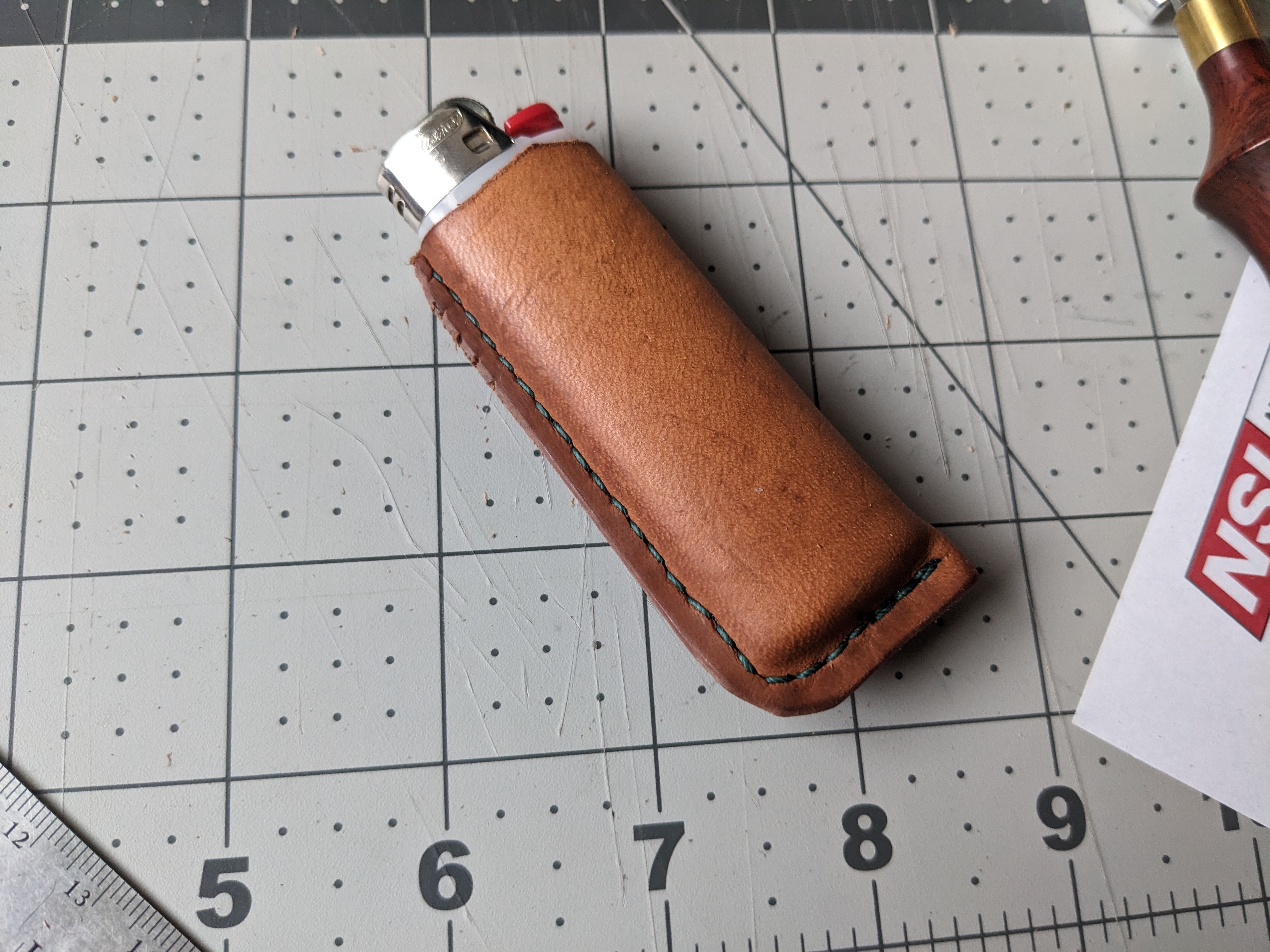 A bic lighter wrapped in leather and hand-stitched up one side.