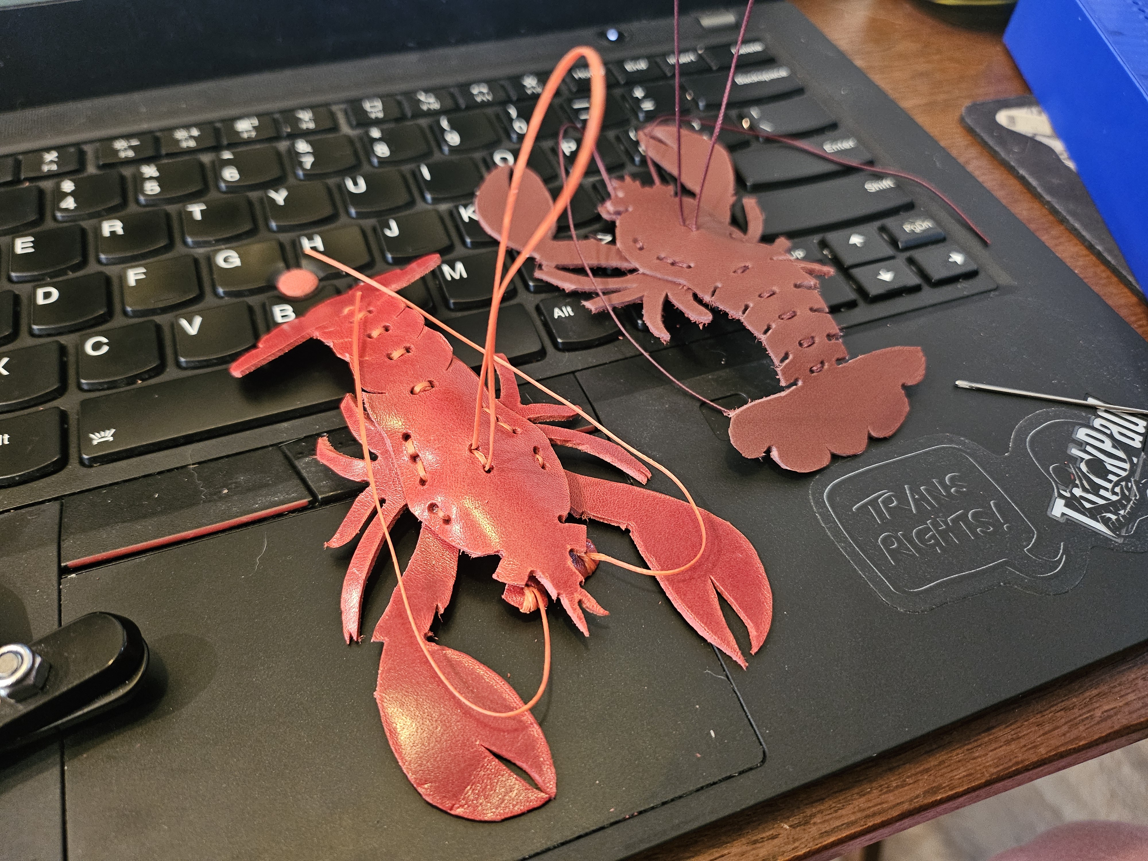 Two red leather lobster ornaments, about 4-5 in long each.