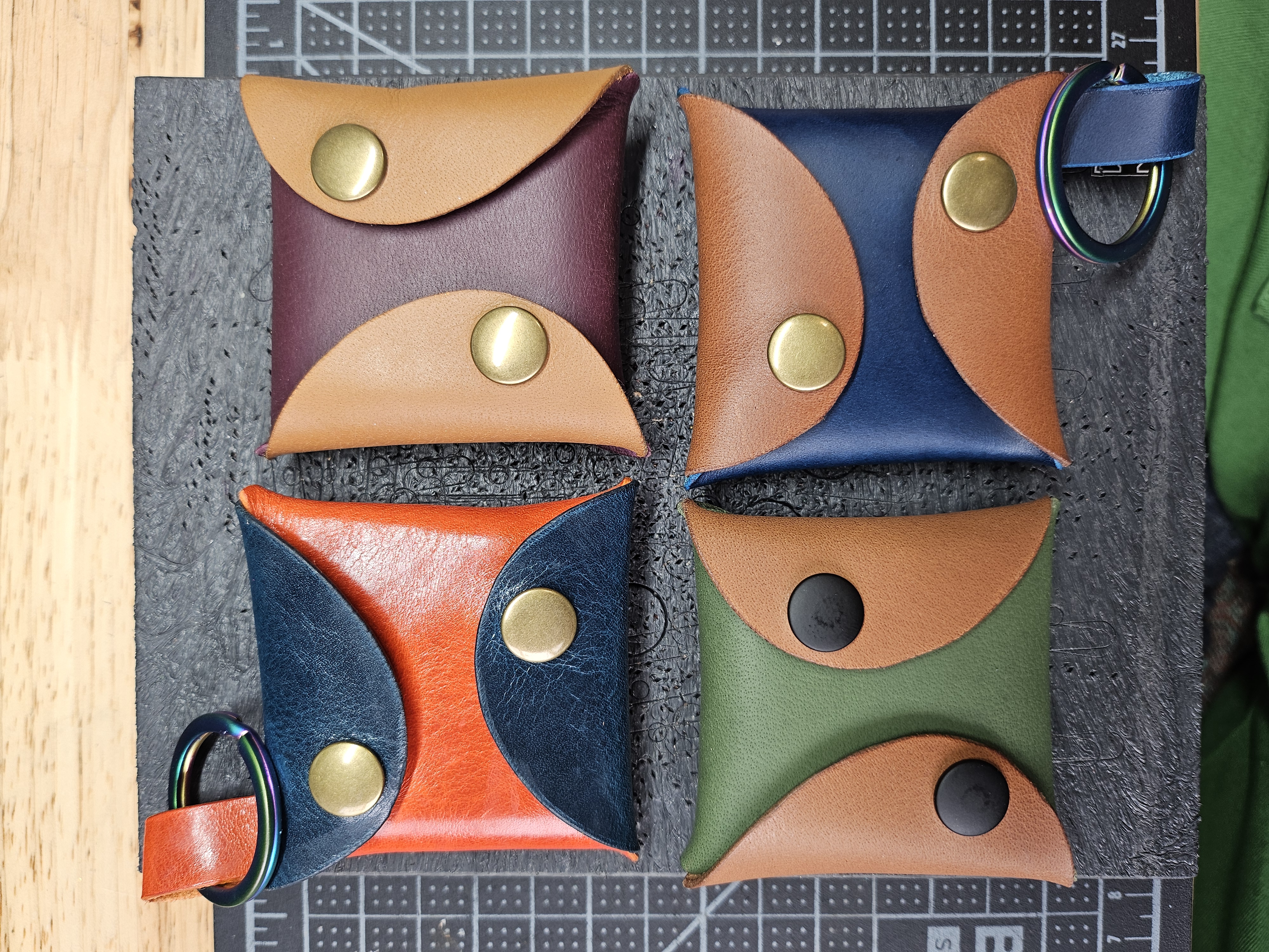 4 square pouches that close with snaps. 2 have loops that attach keyrings. They are in various colors of leather.