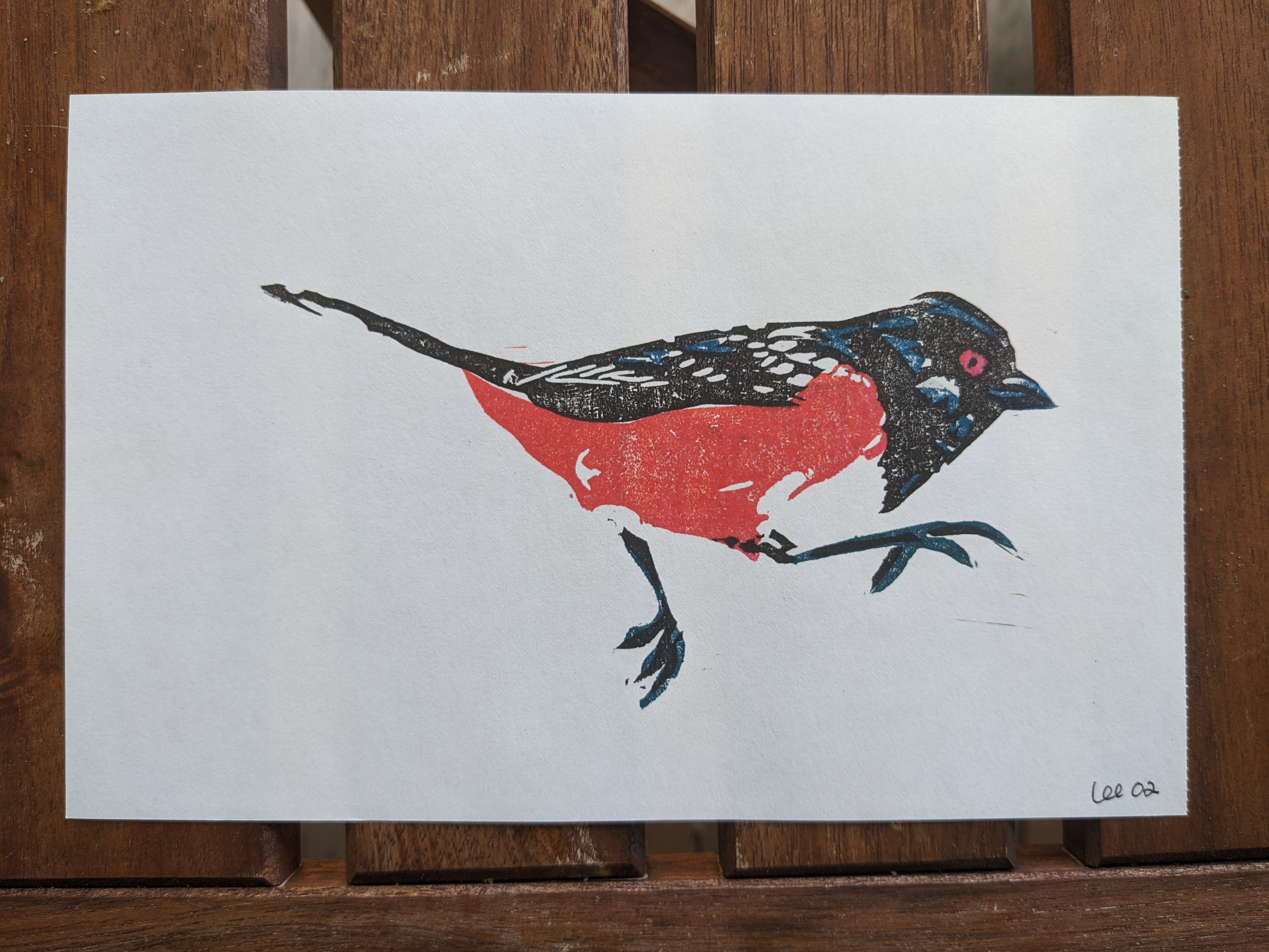 A block print of a spotted towhee mid-leap.