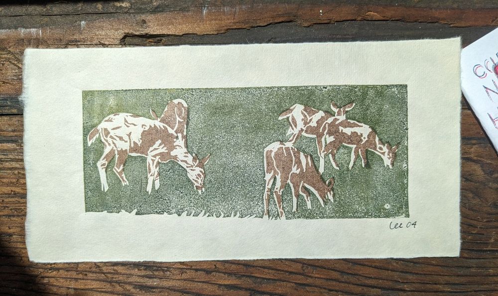 A block print of five mule deer grazing in a dark green field. The deer are partially negative space and partially brown ink detailing.
