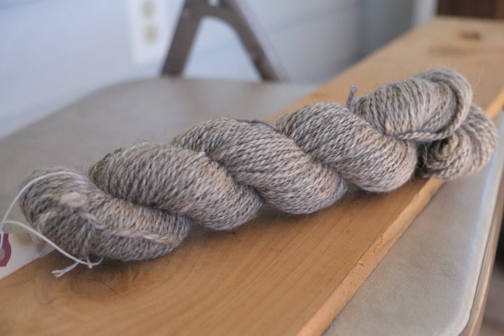 a skein of a lightly variegated grey yarn in about a sport or DK weight.